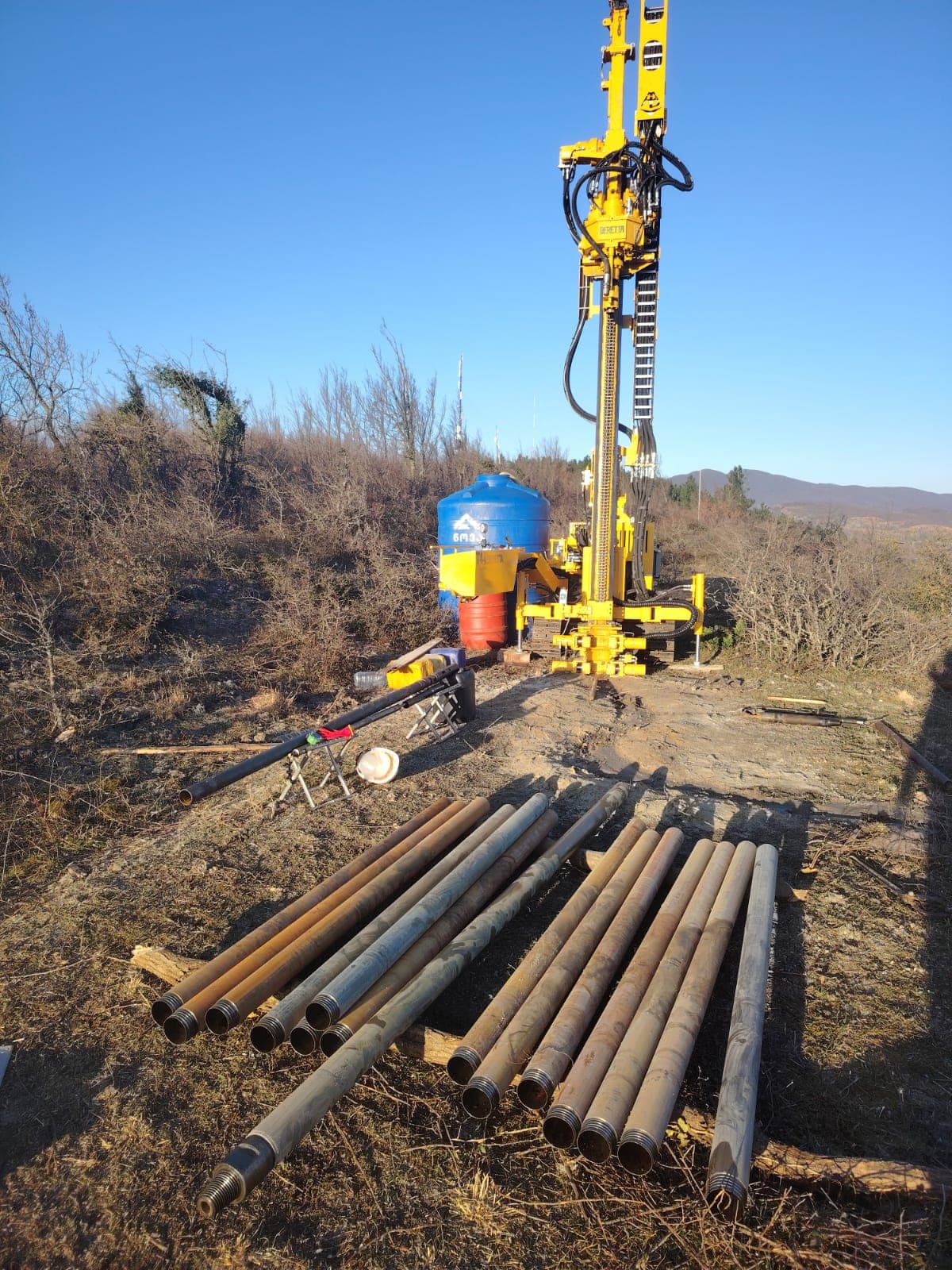 Geologist drill pipes and rotary drilling equipment on site near Kutaisi for wind turbine foundation survey